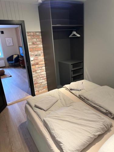 a bedroom with two beds and a room with a chair at Nice apartment close to the sea with parking and garden in Arendal