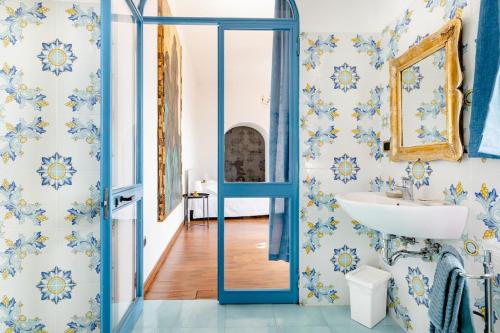タオルミーナにあるIsola Bella - Rooms il Pescatoreの青いドアとシンク付きのバスルーム