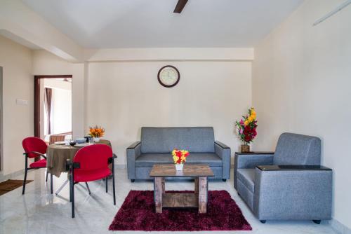 a living room with two blue chairs and a table at Aafiya lakeview Apartments in Coimbatore