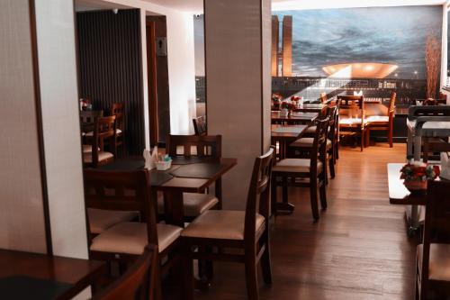 une salle à manger avec des tables et des chaises en bois dans l'établissement Vida Plaza Hotel, à Brasilia