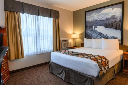 a hotel room with a bed and a large window at Super 8 by Wyndham Cochrane in Cochrane