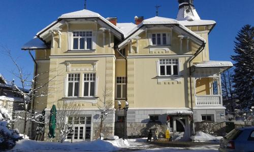 a large yellow house with snow on it at Guest House Veronika in Kočevje
