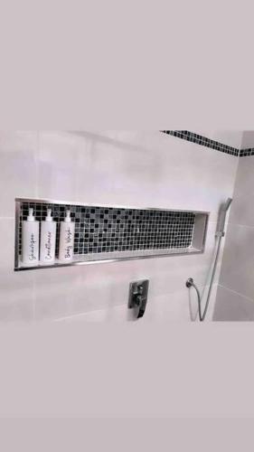 a bathroom with a shelf with four bottles of soap at The BnB filled to the brim with character & charm! in Dubbo