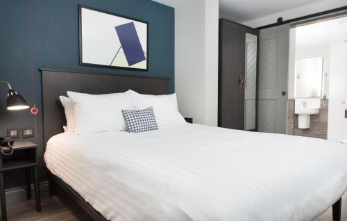 a bedroom with a large white bed and a bathroom at Residence Inn by Marriott London Tower Bridge in London