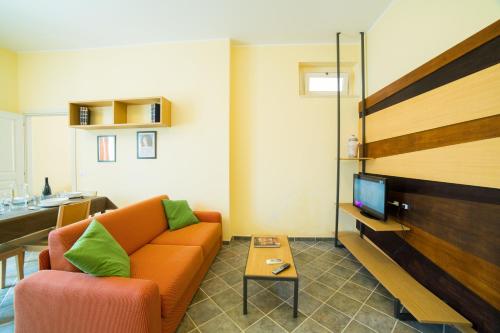 a living room with an orange couch and a tv at Dimora De Mauro in Catania