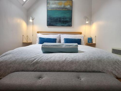 a bedroom with a large bed with blue pillows at Guest Homes - Clara Cottage in Bretforton