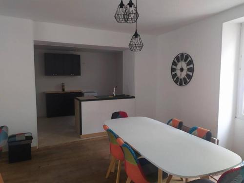 a dining room with a white table and chairs at Maison de ville très lumineuse in Civray