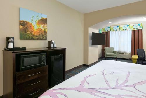 a hotel room with a bed and a tv at La Quinta by Wyndham Dallas Grand Prairie South in Grand Prairie