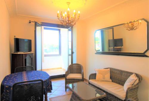 ein Wohnzimmer mit einem Sofa und einem Spiegel in der Unterkunft MARCOGDUR - Appartement pour 4 personnes à 100m de la plage situé aux Marines de Cogolin in Cogolin