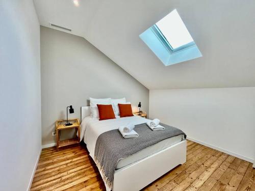 a bedroom with a large bed with a skylight at Le Bohème / zone sud - DABNB in Limoges