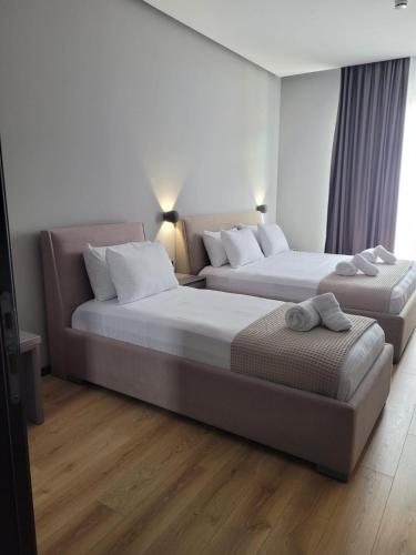 a hotel room with two beds and a couch at Toer Hotel & SPA in Sarandë