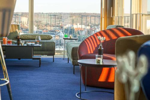 a hotel room with couches and tables with a view at Parkhotel Heilbronn in Heilbronn