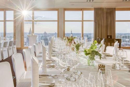 a long table with white chairs and wine glasses at Parkhotel Heilbronn in Heilbronn