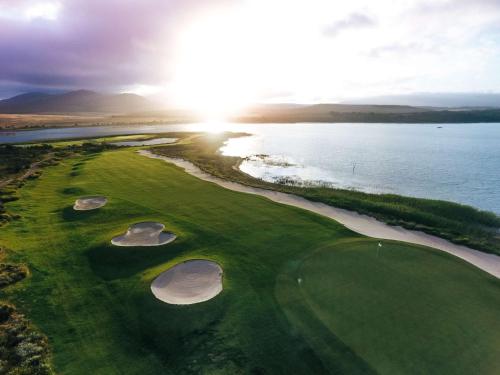 an aerial view of a golf course next to the water at Arabella Hotel, Golf and Spa in Kleinmond