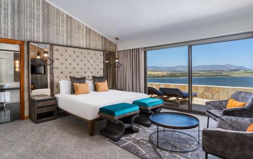 a bedroom with a bed and a room with a view at Arabella Hotel, Golf and Spa in Kleinmond