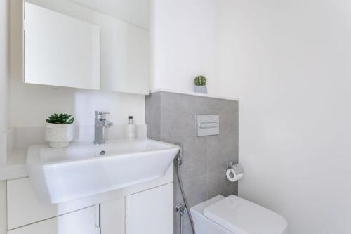 La salle de bains blanche est pourvue d'un lavabo et de toilettes. dans l'établissement Frank Porter - Ahad Residences, à Dubaï