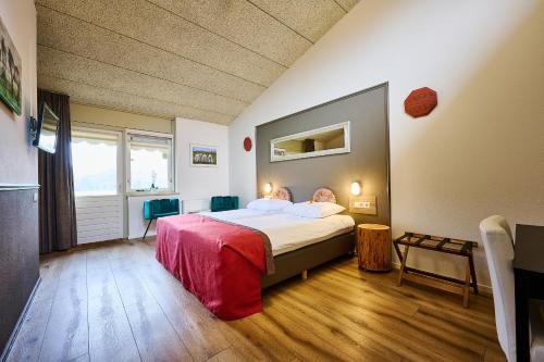 a bedroom with a bed with a person laying on it at Landhotel Diever in Diever