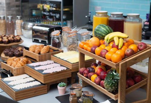 a buffet with baskets of fruits and vegetables and bread at Residence Inn by Marriott London Tower Bridge in London