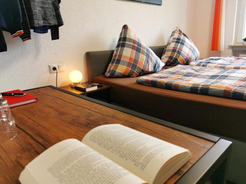 a book on a table with a bed and a couch at Speedys Bed & Breakfast in Reimerath