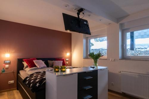 オルスベルクにあるAm Höhlchenのベッドルーム1室(ベッド1台、壁掛けテレビ付)