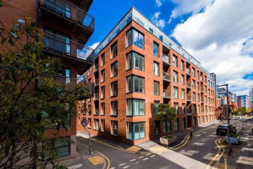un edificio alto de ladrillo en una calle de la ciudad con una calle en Hilltop Serviced Apartments- Northern Quarter, en Mánchester
