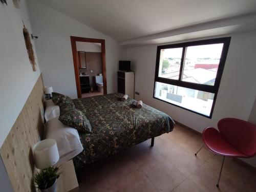 a bedroom with a bed and a large window at Hostal Espai Mediterrani in Puebla de Vallbona