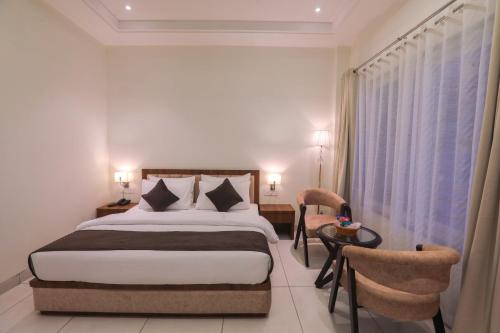 a hotel room with a bed and a table and chairs at The VrindHuts in Vrindāvan