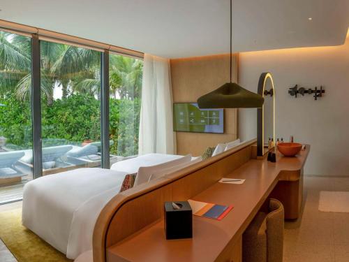 SO/ Maldives في مالي أتول الجنوبية: غرفة نوم بسرير ومكتب ونافذة