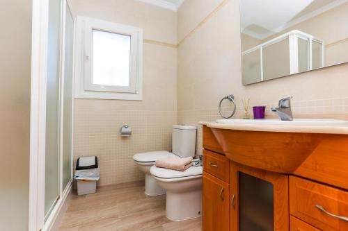 デニアにあるVilla Santa Luciaのバスルーム(トイレ、洗面台付)、窓が備わります。