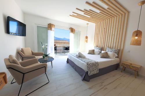 a bedroom with a bed and a couch and a chair at La Manufacture D'oriano LES NUITS AU VILLAGE in Montegrosso