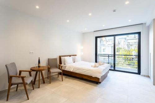 1 dormitorio con 1 cama, mesa y sillas en Athens Grec Suites - The Ultimate City Getaways In Dafni en Athens
