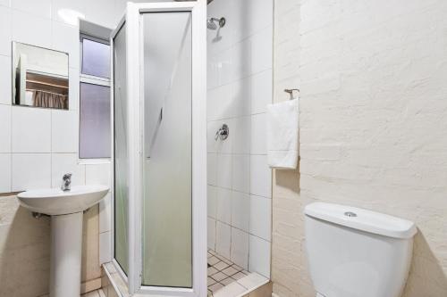 une salle de bain blanche avec toilettes et lavabo dans l'établissement The Hub 602 by Host Agents, au Cap