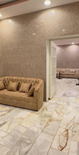 a living room with a couch and a wall at شاليه السلوى in Hafr Al Baten