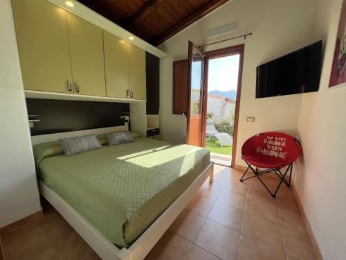 una camera con letto e sedia rossa di Affittimoderni Viddalba - Villaggio Casteldoria a Viddalba