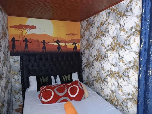 - une chambre avec un lit orné d'une peinture murale dans l'établissement Lukemanbnb Studio, à Voi