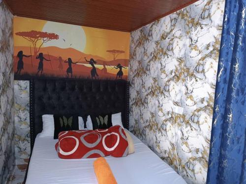 - une chambre avec un lit orné d'une peinture murale dans l'établissement Lukemanbnb Studio, à Voi