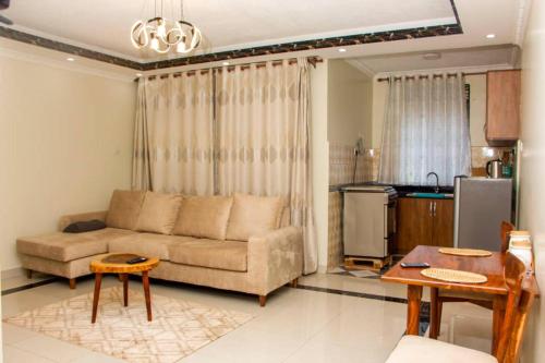 een woonkamer met een bank en een keuken bij Spacious- Brb Homes Bukoto in Kampala