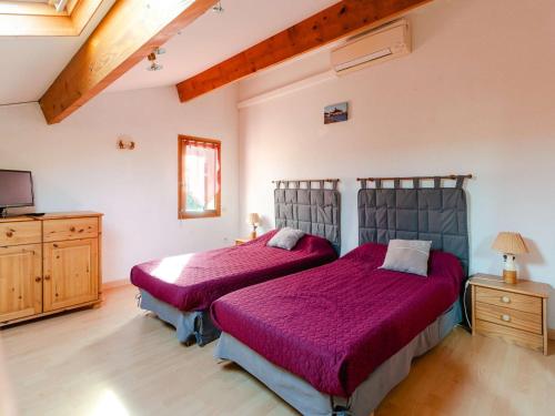 - une chambre avec 2 lits dotés de draps violets et une télévision dans l'établissement Pavillon Climatisé T2 Mezzanine à 150m de la Plage - 5 Pers, Parking, Animaux Acceptés - FR-1-409-250, à Gruissan