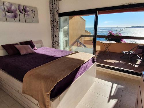une chambre avec un lit et une vue sur l'océan dans l'établissement Appartement 4 pièces avec piscine, climatisation et accès plage à Sainte-Maxime - FR-1-780-34, à Sainte-Maxime