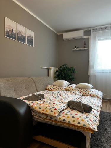 a bed with a comforter on it in a room at Renapartman in Pécs