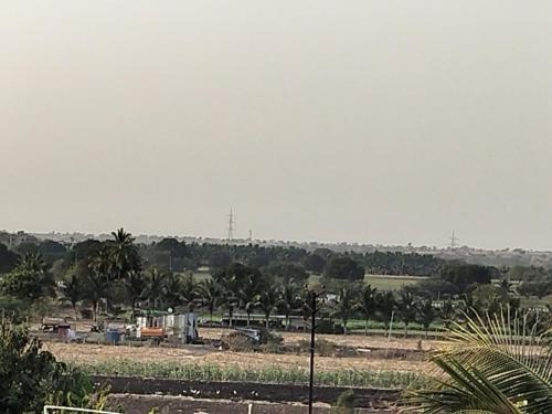 vista su un campo alberato e su edifici di Samarth Sawali Guest House, Vidhyanagar Akkalkot a Akalkot