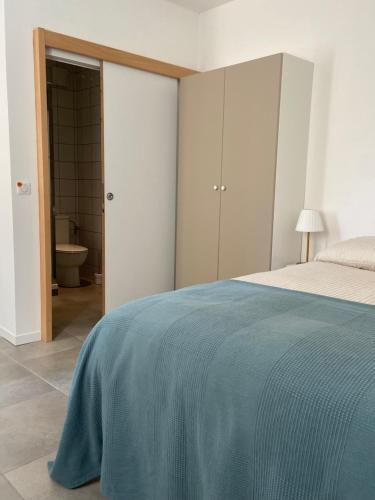 um quarto com uma cama com um cobertor azul em Studio - Cœur de Ville em Sérignan