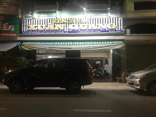 un'auto parcheggiata di fronte a un edificio di notte di Khách Sạn Xuân Quang a Can Tho