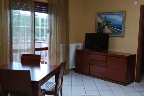 ein Wohnzimmer mit einem Tisch und einem TV auf einer Kommode in der Unterkunft Bilocale centrale 80 MQ, con terrazza abitabile in Tortoreto Lido