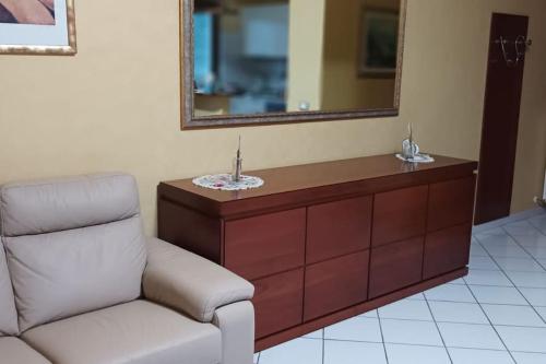 ein Wohnzimmer mit einem Stuhl und einem Spiegel in der Unterkunft Bilocale centrale 80 MQ, con terrazza abitabile in Tortoreto Lido