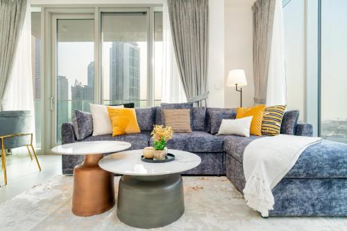 een woonkamer met een blauwe bank en een tafel bij Mystic - Forte Tower 2 in Dubai