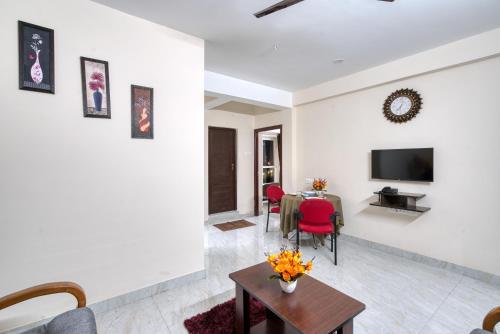 a living room with a table and a tv at Aafiya lakeview Apartments in Coimbatore
