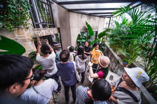 a group of people standing in a crowd at Chengdu Local Tea Hostel - Short Walk To Taikooli - Chill & Social Coffee Lounge - Metro downstairs - Free Activities - Friendly English Speaking Staff - Tibet, Panda, Buddha & Snow Mountain Tours in Chengdu