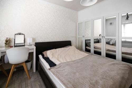 a bedroom with a bed and a desk and a chair at Talo Kerava in Kerava