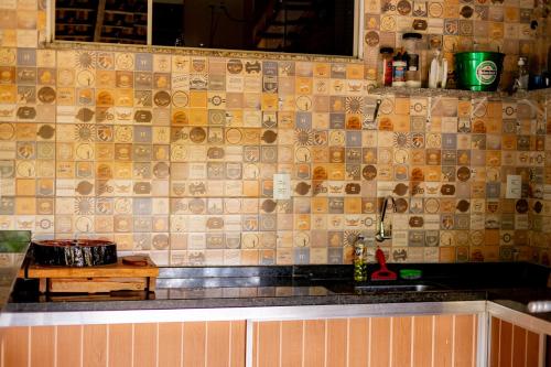 uma cozinha com uma parede em azulejo e uma bancada em Chacara em otima localizacao em Arthur Nogueira SP em Artur Nogueira